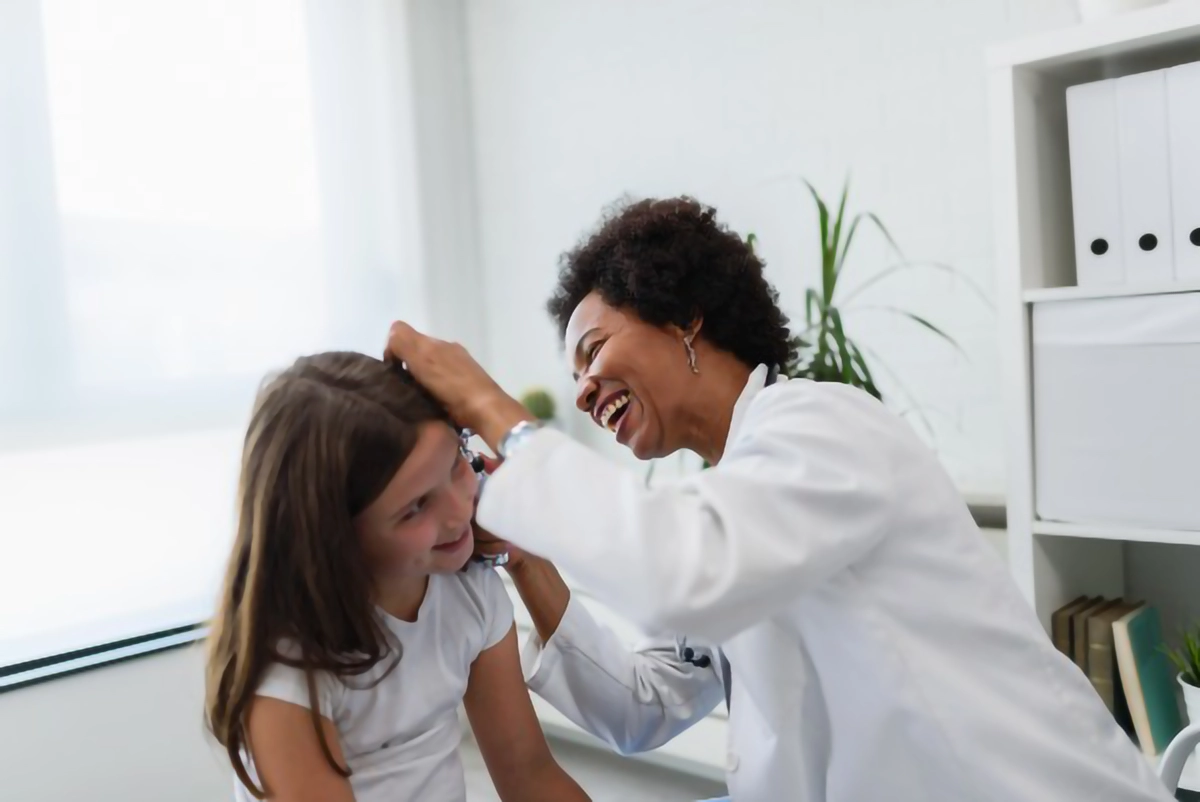 Image of a doctor checking ears of a young patient